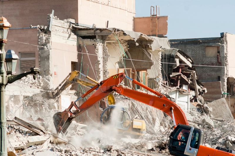 two excavators demolishing a building
